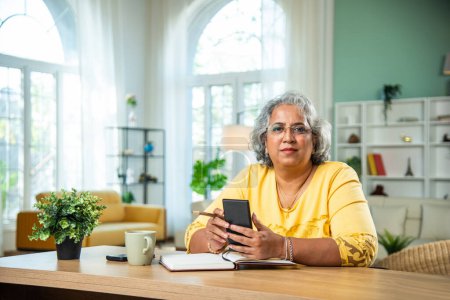 Photo for Indian senior lady using laptop, computer at home office - Royalty Free Image