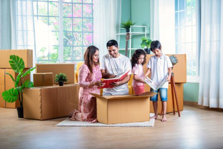 Photo for House move concept. Happy Indian young family sitting on the floor in new home - Royalty Free Image