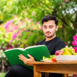 Indian man reading book outdoors