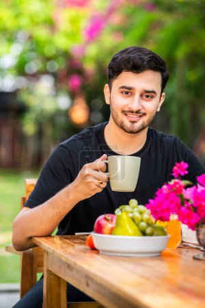 Photo for Indian man outdoors having coffee or juice - Royalty Free Image