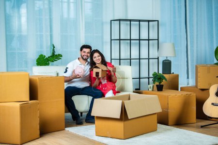 Foto de India pareja y hogar móvil concepto con alcancía y cajas de cartón - Imagen libre de derechos