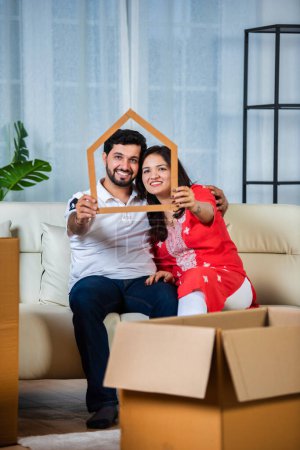 Photo for Indian couple and home moving concept with piggy bank and cardboard boxes - Royalty Free Image