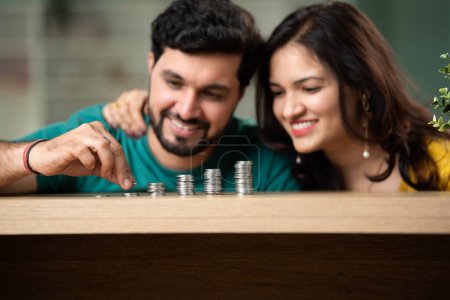 Photo for Indian asian couple and saving concept with stack or towers of coins on desk - Royalty Free Image