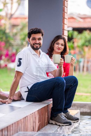 Photo for Indian asian young couple spending quality time having coffee outdoors - Royalty Free Image