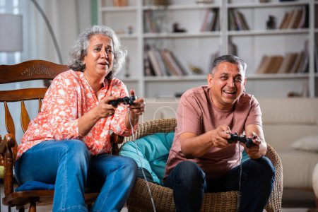 Foto de Mediados de edad pareja india divertirse jugando videojuegos - Imagen libre de derechos