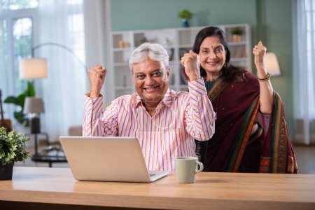 Photo for Mature Indian asian couple surfing the Internet on laptop at home - Royalty Free Image