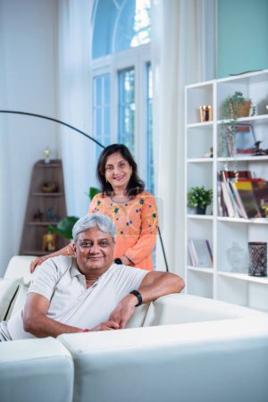 Photo for Elderly Indian asian couple sitting on sofa or couch in living room - Royalty Free Image