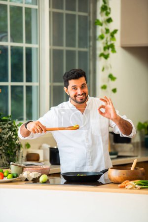 Indischer Mann kocht allein in Küche