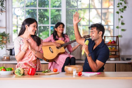 Foto de Familia india cantando guitarra en la cocina - Imagen libre de derechos