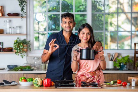 Foto de India asiático pareja preparando comida en la estufa con pareja en cocina - Imagen libre de derechos