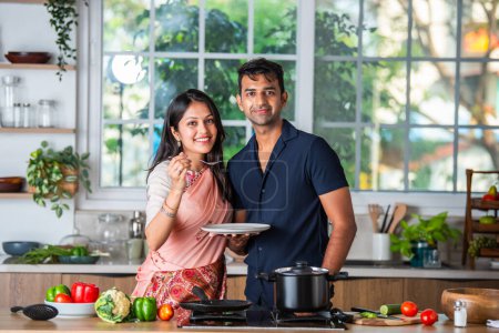 Téléchargez les photos : Indien asiatique jeune couple tenant vide assiette ou dégustation de nourriture - en image libre de droit