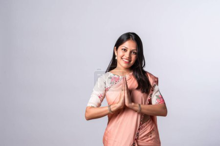 Téléchargez les photos : Indien asiatique jeune femme dans bienvenue namaskar ou namaste pose dans saree - en image libre de droit