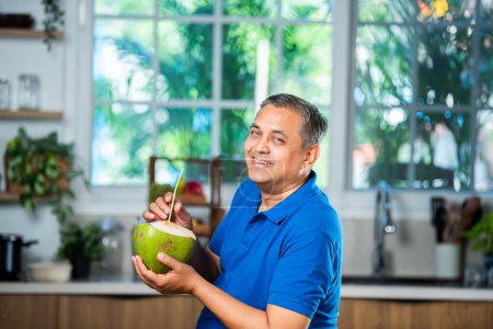 Téléchargez les photos : Indien asiatique homme boire nutritius savoureux frais noix de coco eau - en image libre de droit