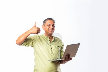 Photo for Mid age indian asian handsome man using laptop computer, standing or sitting against white background - Royalty Free Image
