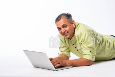 Foto de Mediados de edad indio asiático guapo hombre usando ordenador portátil, de pie o sentado sobre fondo blanco - Imagen libre de derechos