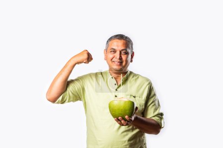 Téléchargez les photos : Indien asiatique homme boire nutritius savoureux frais noix de coco eau - en image libre de droit
