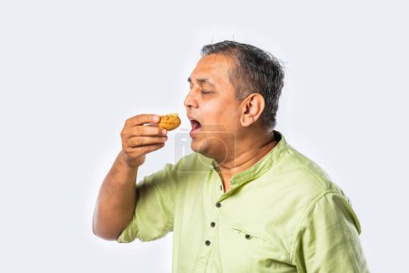 Indian asian elderly man enjoys eating golgappa or panipuri a streetfood