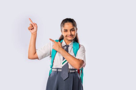 Photo for Indian asian schoolgirl wears school uniform and standing with backpack - Royalty Free Image