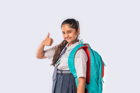 Téléchargez les photos : Indien asiatique écolière porte école uniforme et debout avec sac à dos - en image libre de droit
