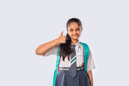 Téléchargez les photos : Indien asiatique écolière porte école uniforme et debout avec sac à dos - en image libre de droit