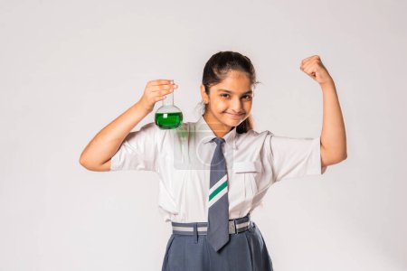 Foto de India asiático colegiala en escuela uniforme haciendo ciencia experimento con químico en frasco - Imagen libre de derechos
