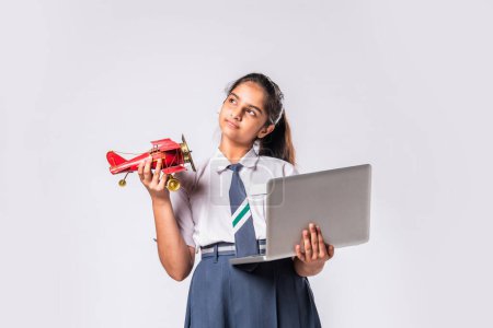 Téléchargez les photos : Indien asiatique écolière en uniforme scolaire étudiant la science impliqué dans la fabrication avion - en image libre de droit
