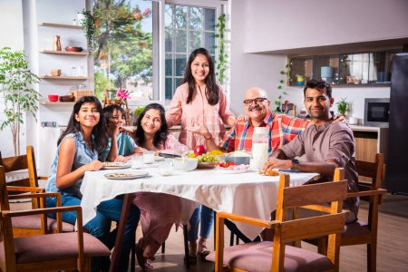 Foto de Feliz multi-generación asiático indio familia disfrutando almuerzo juntos en casa. - Imagen libre de derechos