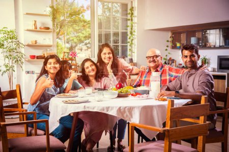 Photo for Happy multi-generation asian Indian family enjoying lunch together at home. - Royalty Free Image