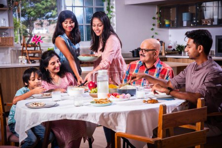 Foto de Feliz multi-generación asiático indio familia disfrutando almuerzo juntos en casa. - Imagen libre de derechos