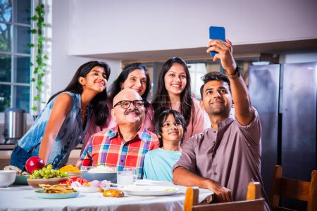 Photo for Indian asian family of six having lunch and taking selfie picture at home - Royalty Free Image