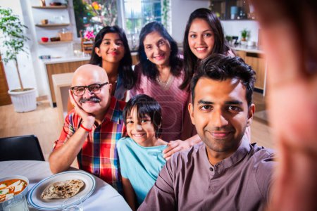 Photo for Indian asian family of six having lunch and taking selfie picture at home - Royalty Free Image