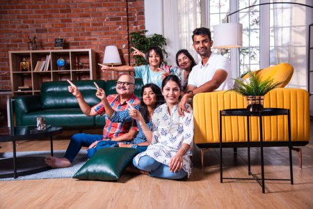 Photo for Group photograph of multigenerational Indian asian family sitting on sofa in living room - Royalty Free Image