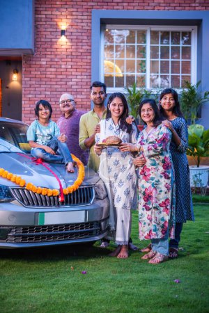 Téléchargez les photos : Indien asiatique famille posant tout en accueillant nouvelle voiture à la maison - en image libre de droit