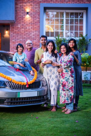 Photo for Indian asian family posing while welcoming new car at home - Royalty Free Image