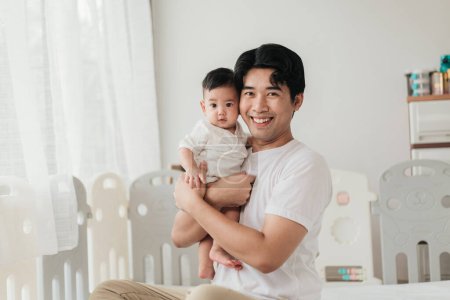 Téléchargez les photos : Asiatique adorable bébé de bonne humeur, Profitez de jouer avec le père. Père tenant le petit bébé et jouant. Concept de fête des pères. - en image libre de droit