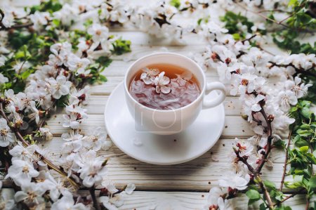 Foto de Taza de té verde y flor de albaricoque de primavera sobre un fondo de madera vintage. Concepto rústico
. - Imagen libre de derechos
