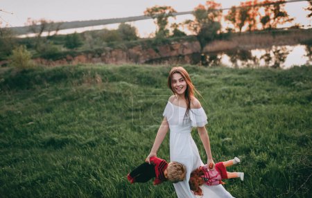 Foto de Mujer joven de aspecto modelo caminando por el campo cerca del río con dos muñecas en sus manos. Una adolescente se imagina que es madre. - Imagen libre de derechos