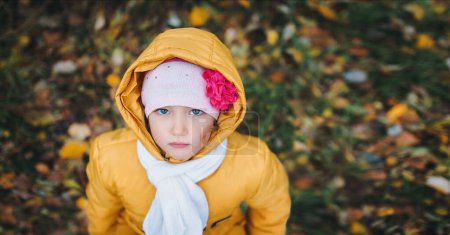 Téléchargez les photos : Une petite fille dans une forêt d'automne vêtue d'une veste jaune avec une capuche. Vue du dessus. - en image libre de droit
