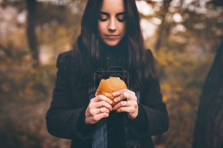 Photo for The concept of hunger and poverty. A roll or hamburger in the girls hands of a close-up. - Royalty Free Image