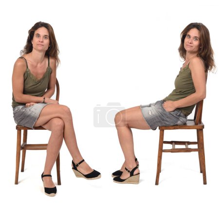 Foto de Vista frontal y lateral de una mujer con falda de mezclilla y spadrille sentado en silla sobre fondo blanco - Imagen libre de derechos