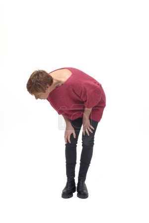 Photo for Crouched woman looking at the ground to the side looking for something on white background - Royalty Free Image