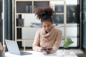 American African Woman working in the office with computer phone and Tablet. High quality photo Poster #647707256