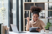 American African Woman working in the office with computer phone and Tablet. High quality photo Poster #647707288