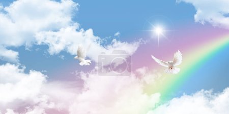 Spectacular rainbow and flying white doves in natural sunny sky. Blue sky and rainbow background