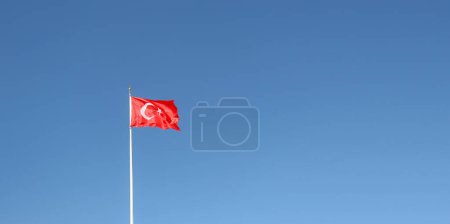 Foto de Turk Bayragi Bandera turca ondeando sobre un fondo azul sin nubes. Foto de fondo para los días nacionales de Turquía. - Imagen libre de derechos