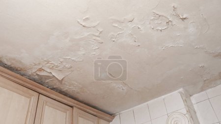 Photo for Dirty and worn interior ceiling after water leak. Water damage apartment room ceiling. - Royalty Free Image
