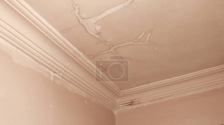 Photo for Dirty ceiling after water leak and moisture. The interior ceiling needs repair. Stained interior ceiling after water damage inside the building. - Royalty Free Image