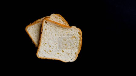 Sliced toast bread on black background. Top view bread slices.