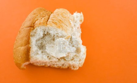 Close-up of delicious cracked loaf of bread isolated on an orange background. 