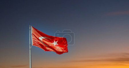 Turk bayragi. Turkish flag waving at sunset sky. Turkish national holidays background image.